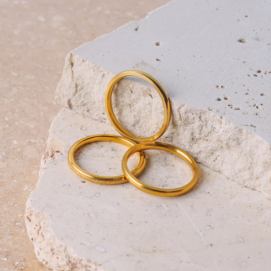Aurora Shimmer Ring – Delta Jewel gold-plated minimalist rings displayed on textured stone, showcasing their sleek design and polished finish.