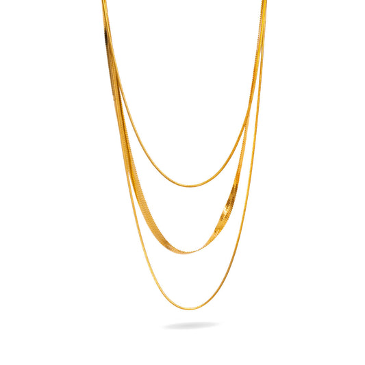 A studio shot on a clean white background displays the Cassie Layered Herringbone Necklace. This gold-toned multi-strand necklace features a prominent flat herringbone chain layered with thinner, delicate chains, all hanging to form a beautiful cascade.