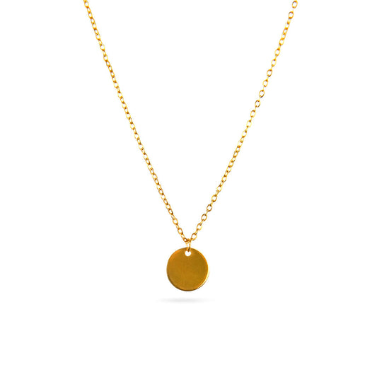 The Luna Disc Necklace is displayed in a studio shot against a bright white background. This elegant gold-toned necklace features a fine chain that suspends a perfectly round, flat, and polished disc pendant.