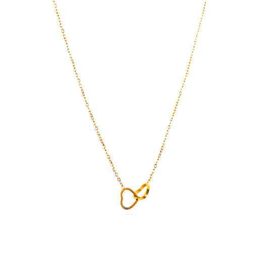 A studio shot on a pristine white background displays the Willow Heart Pendant. This gold-toned necklace has a fine chain and a pair of interlocking heart pendants hanging as a central charm.