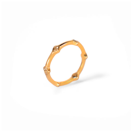 A studio shot on a pristine white background displays the Amara Bamboo Ring. This gold-toned ring has a segmented, bamboo-like design, with some of the segments accented by small, clear gemstones.
