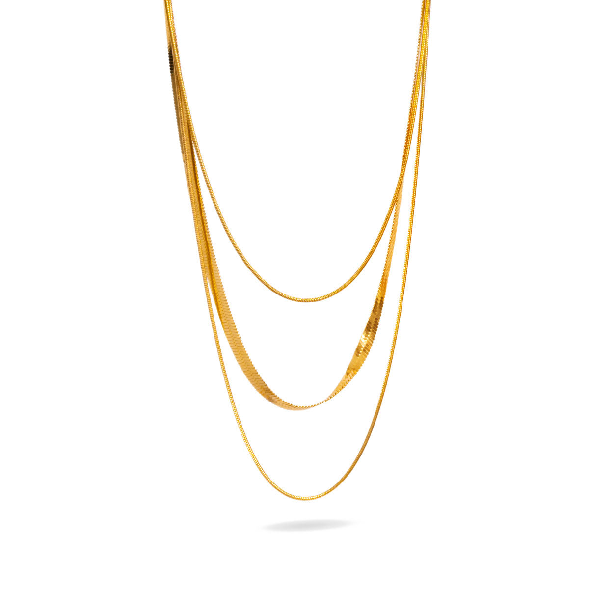 A studio shot on a clean white background displays the Cassie Layered Herringbone Necklace. This gold-toned multi-strand necklace features a prominent flat herringbone chain layered with thinner, delicate chains, all hanging to form a beautiful cascade.