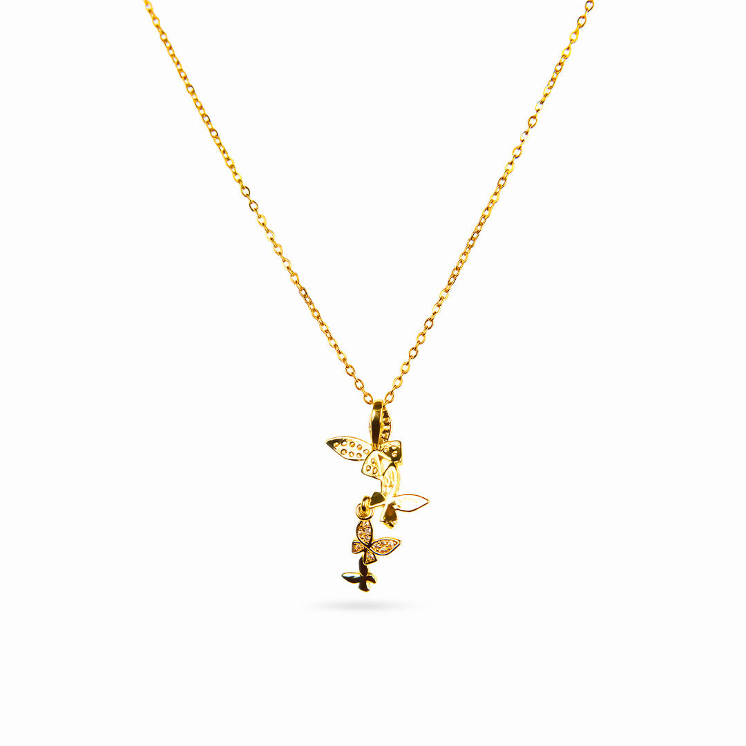 A studio shot on a white background displays the Celeste Butterfly Necklace. This gold-toned necklace has a fine chain and a vertical arrangement of four butterfly pendants, two of which are detailed with sparkling clear gemstones.