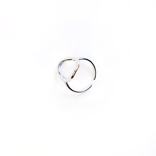 The Celeste Teardrop Ring, a polished silver-toned ring with an abstract open teardrop shape, is showcased in a studio shot on a pristine white background.