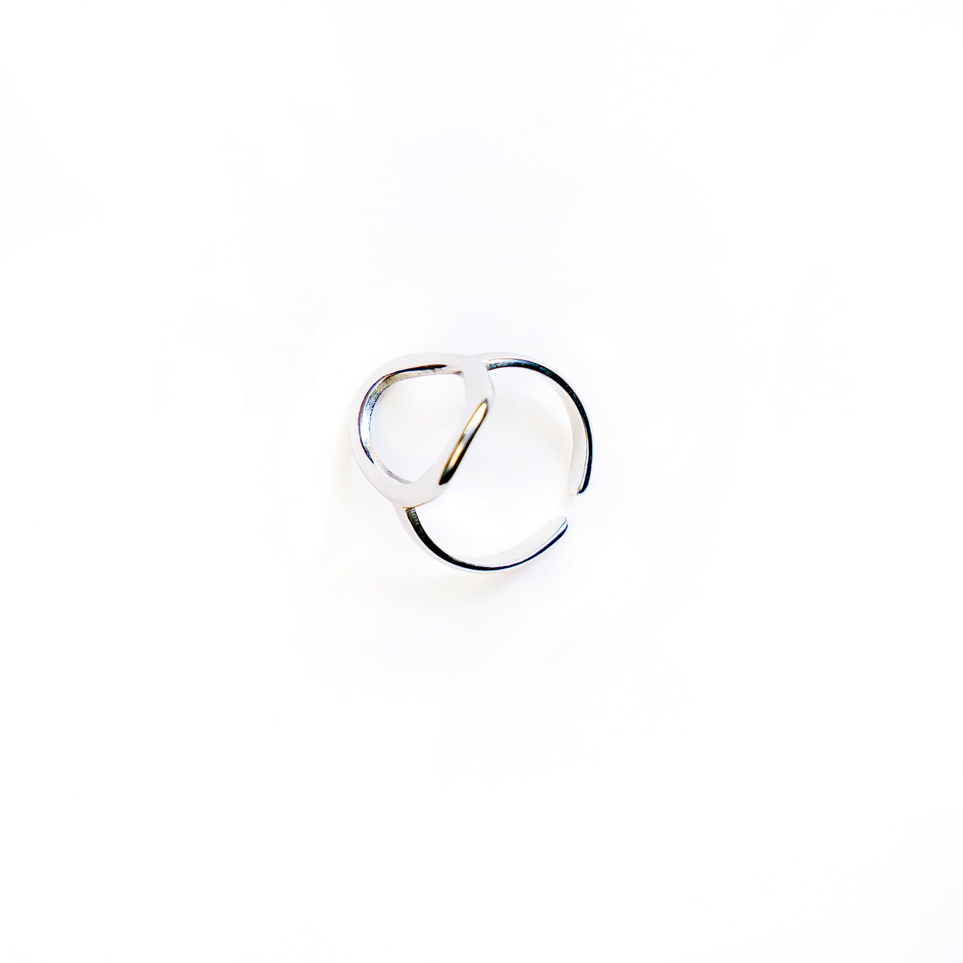 The Celeste Teardrop Ring, a polished silver-toned ring with an abstract open teardrop shape, is showcased in a studio shot on a pristine white background.