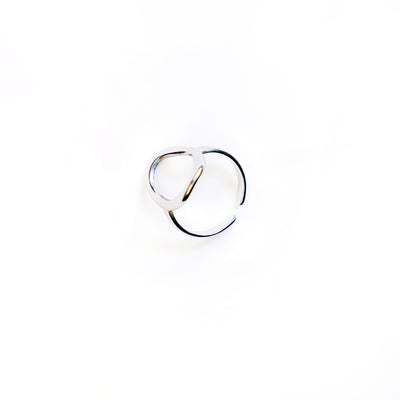 The Celeste Teardrop Ring, a polished silver-toned ring with an abstract open teardrop shape, is showcased in a studio shot on a pristine white background.