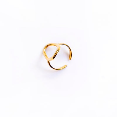 A studio shot on a pristine white background displays the Chloe Open Teardrop Ring. This gold-toned ring features a polished, abstract open teardrop shape, with one end extending to form an adjustable band.
