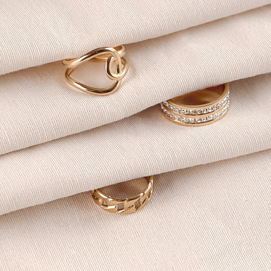  Delta Jewel ring trio featuring the Seraphine Charm Ring, Evelyn Grace Ring, and Dahlia Glow Band — all crafted in high-quality stainless steel with luxurious gold plating, displayed together in a curated flat lay.