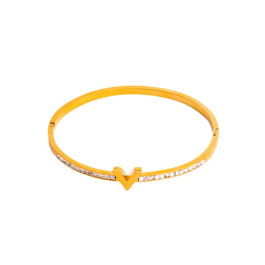 A studio shot on a pristine white background displays the Elysian Sparkle Bracelet. This gold-toned bangle is designed with a prominent V-shape at its center and a continuous row of shimmering gemstones along its upper surface.