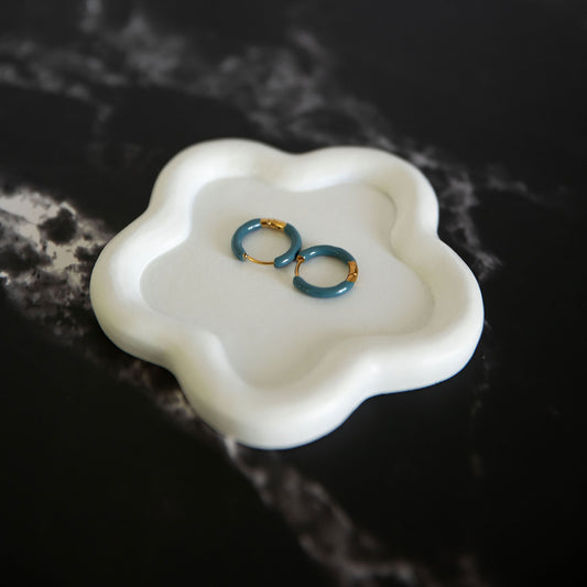 Evelyn Dusk enamel and gold hoop earrings in deep teal, displayed on a white ceramic dish – Delta Jewel