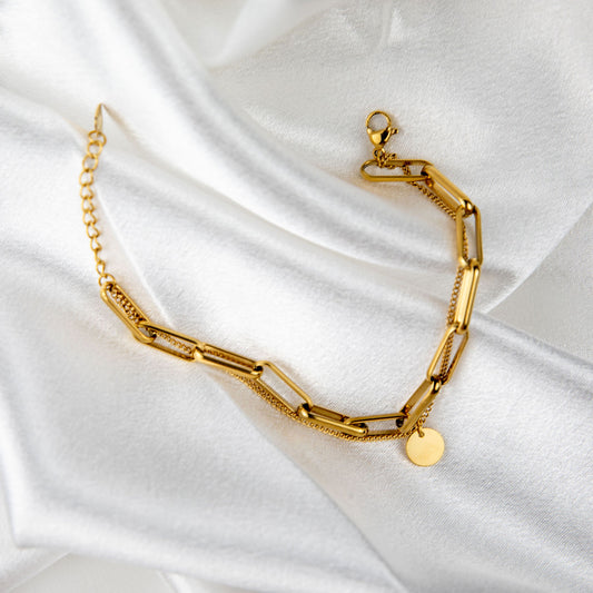 Marisol Charm gold-plated chain bracelet with disc charm styled on white satin fabric – Delta Jewel