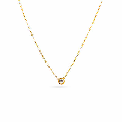 A studio shot on a pristine white background displays the Parker Spheroid Necklace. This gold-toned necklace has a fine chain that forms a gentle V-shape, suspending a single, round, bezel-set gemstone.