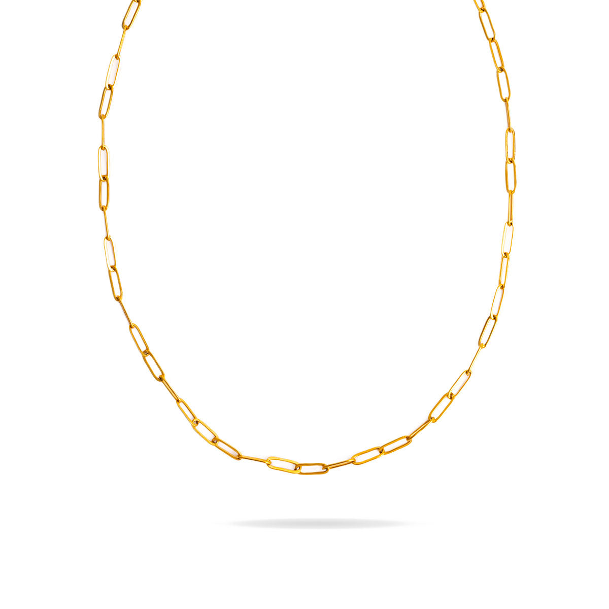 A studio shot on a bright white background displays the Serena Paperclip Necklace. The gold-toned necklace forms a gentle U-shape, highlighting its continuous chain of polished paperclip-style links.