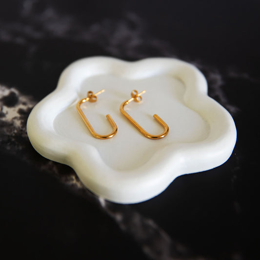 Sienna Gold minimalist U-shaped earrings on a sculpted white ceramic tray – Delta Jewel