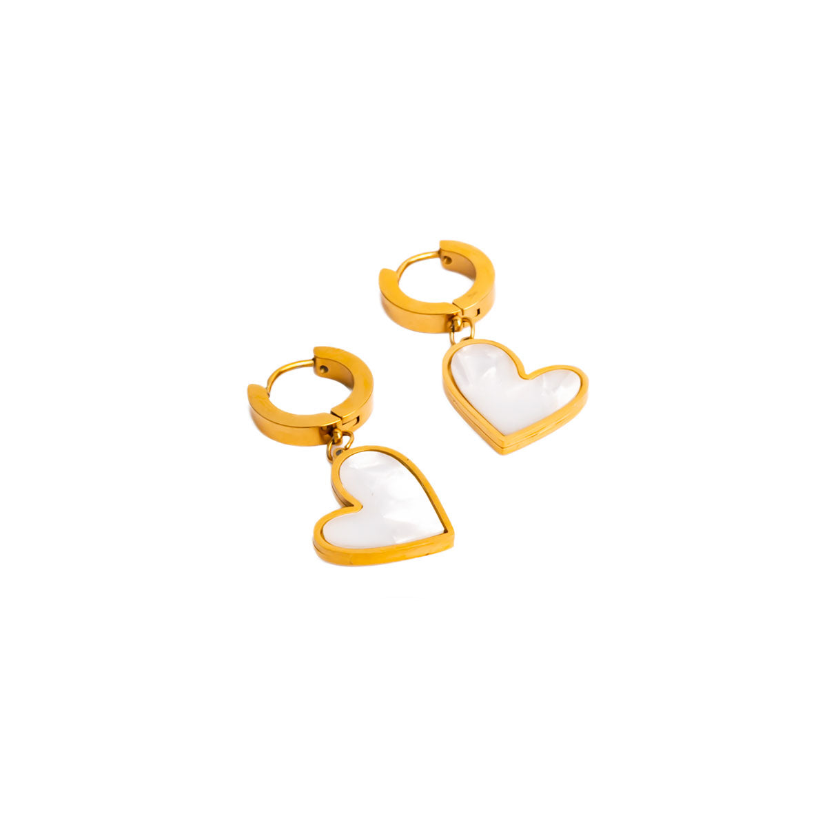 A studio shot on a clean white background displays the Venus Heart Drops. Each gold-toned earring consists of a small, shiny hoop from which a heart-shaped charm with a white, polished inlay dangles.