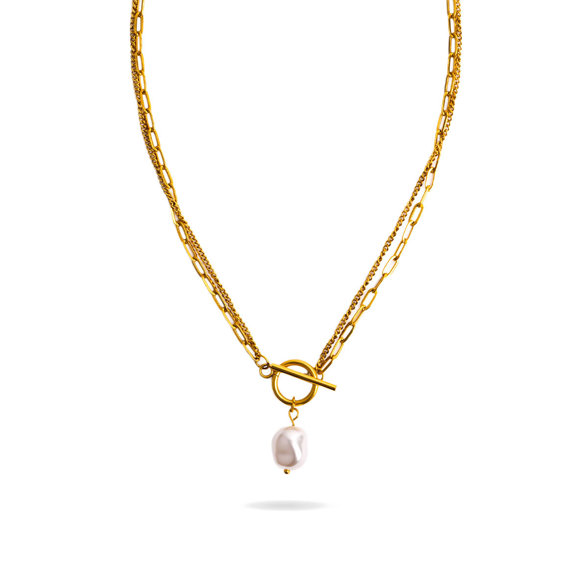 A studio shot on a white background displays the Solara Toggle Pearl Necklace. The gold-toned, layered necklace is suspended, showing a chunky chain and a finer chain connected by a toggle clasp from which a single, large, irregular white pearl dangles.